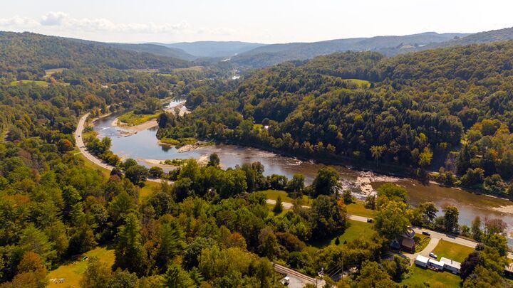 River winding through a forested valley in late summer