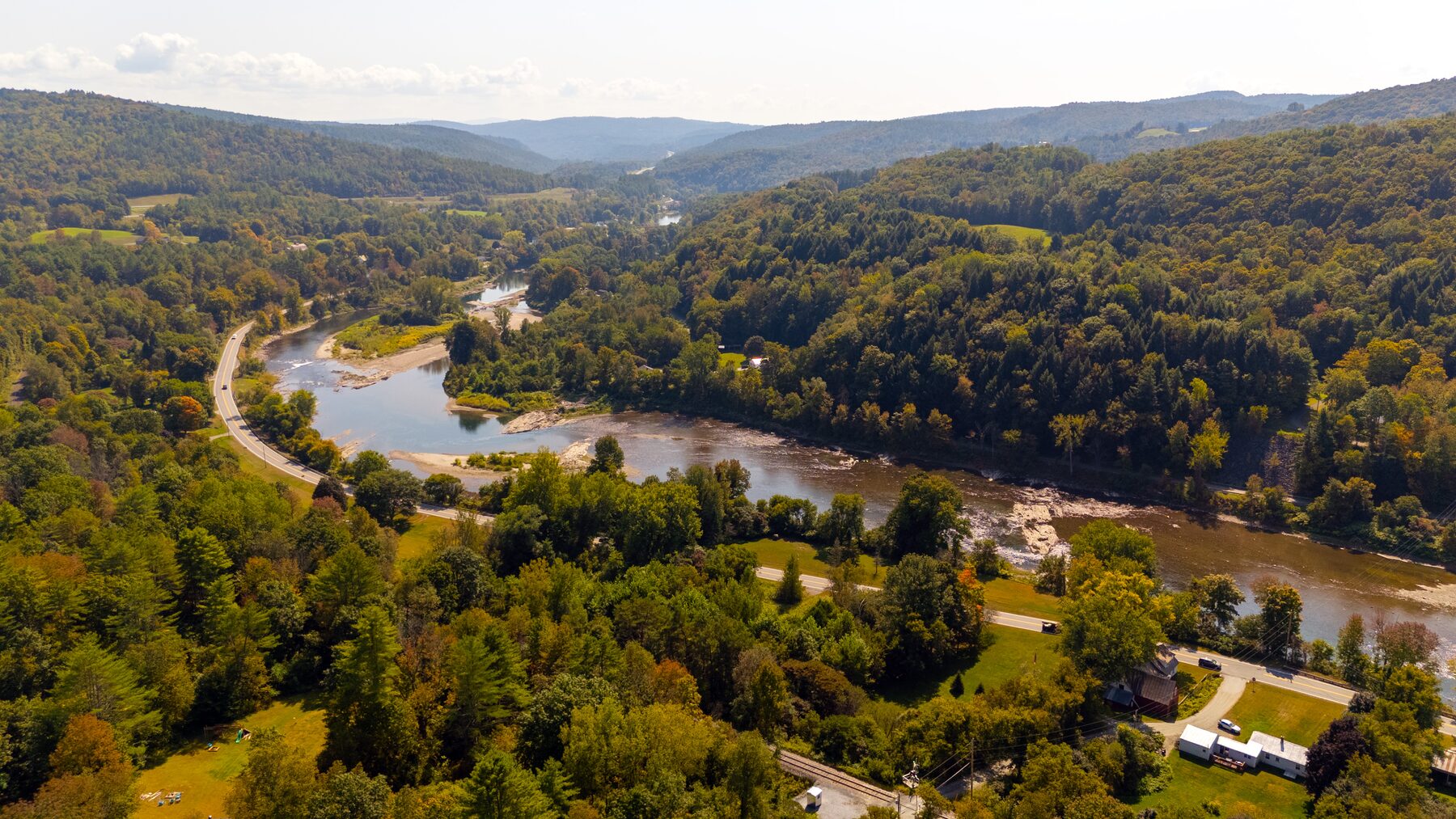 River winding through a forested valley in late summer