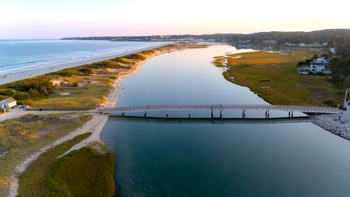 Footbridge over a tidal creek beside a long sandy beach