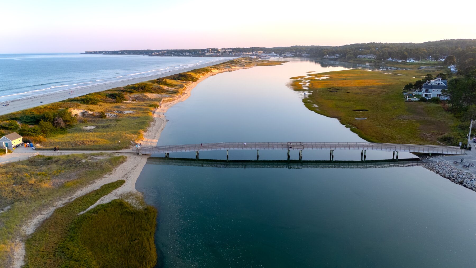 Footbridge over a tidal creek beside a long sandy beach