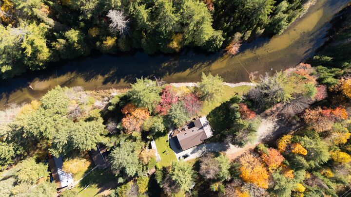 Cottage beside a river bend in autumn, from directly overhead