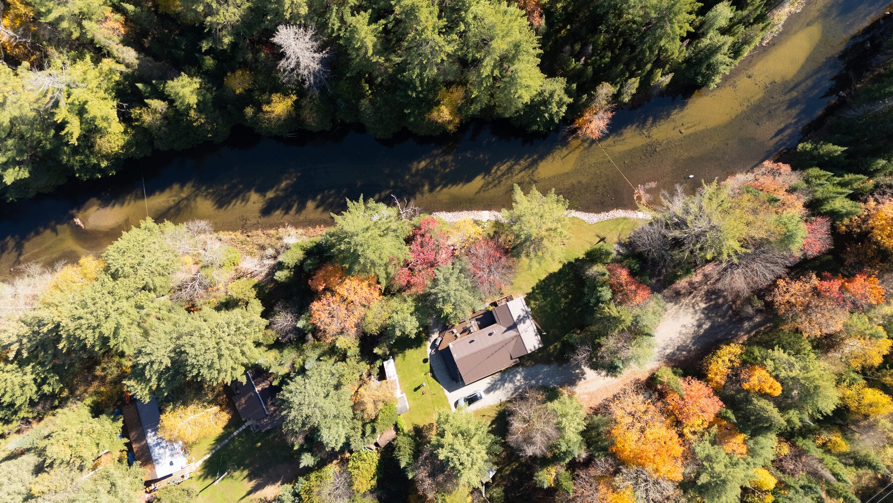 Cottage beside a river bend in autumn, from directly overhead