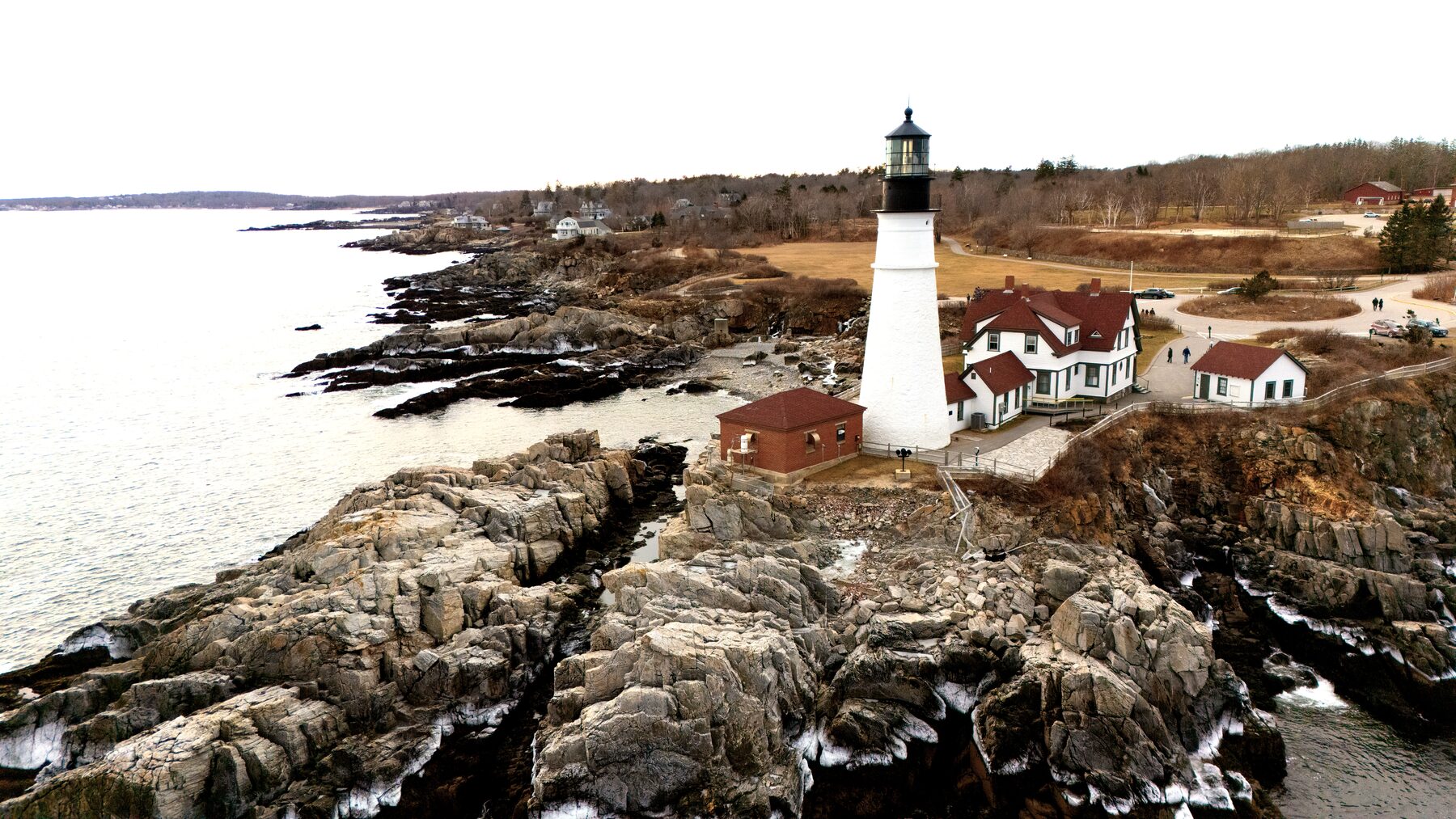 Lighthouse and keeper's house on a rocky headland in winter light