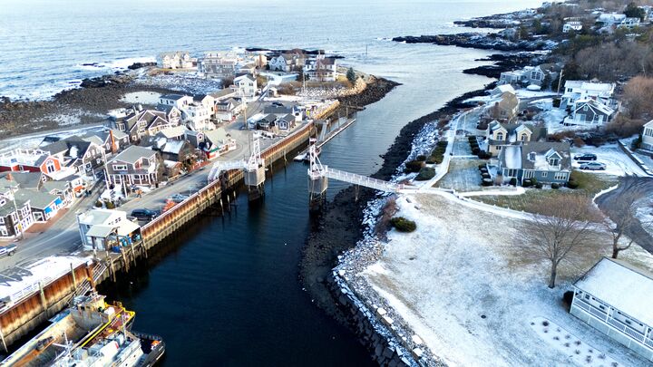 Harbour town under fresh snow, with a drawbridge and boats